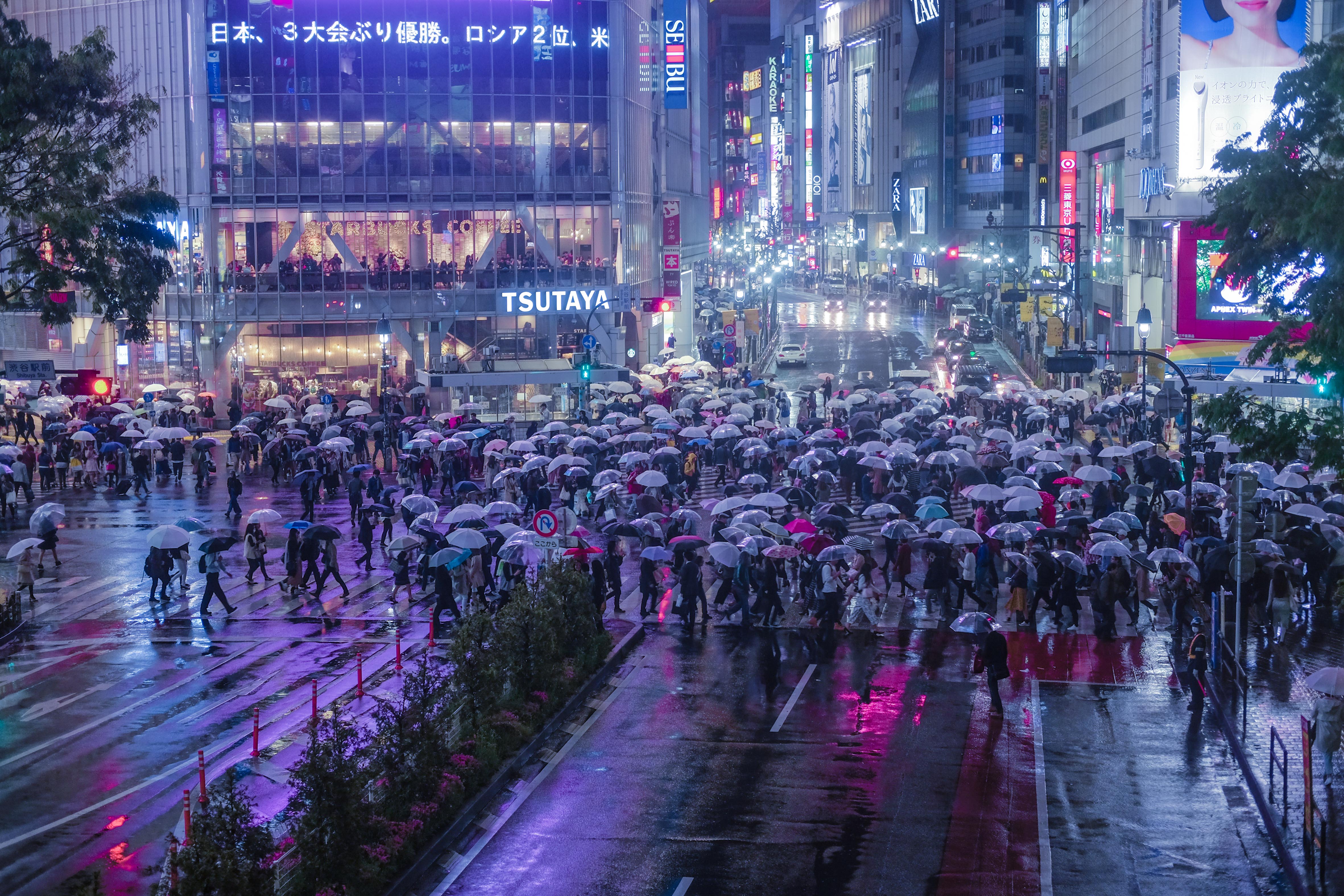人们在夜晚穿过著名的涩谷十字路口